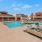 a swimming pool with chairs and a building behind it