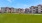 a row of buildings with a park and grass