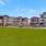 a row of buildings with a park and grass