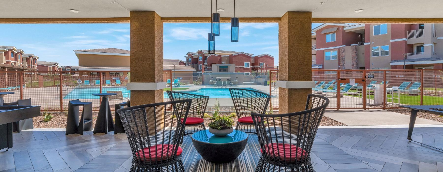 a patio with a table and chairs near a pool
